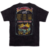 Black mineral wash tee shirt, back: Grateful Dead Spring Tour 1977 poster with tour dates and cities. Under text there is a stylized flower with skeleton emerging from the bud.