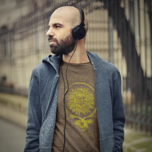 Man wearing heather brown Grateful Dead t-shirt listening to music